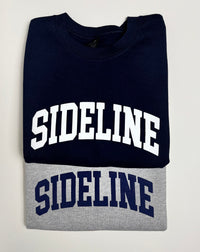 Gray and navy cozy crewneck sweaters with logo from Sideline Bags.